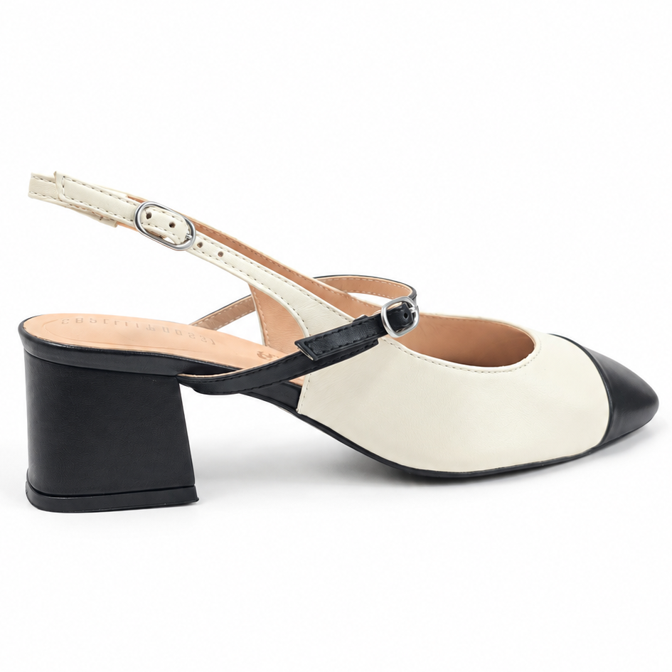 A women's block-heel slingback shoe with a cream and black color-blocked design, featuring a pointed toe, a thin ankle strap with a silver buckle, and a low block heel.